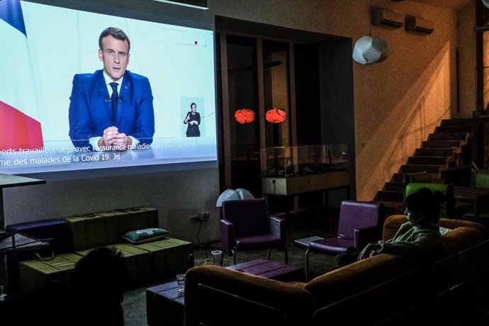 24 November 2020, France, Paris: A woman watches a televised address to the nation by French President Emmanuel Macron, on a video projector at her house. Photo: Sadak Souici/Le Pictorium Agency via ZUMA/dpa