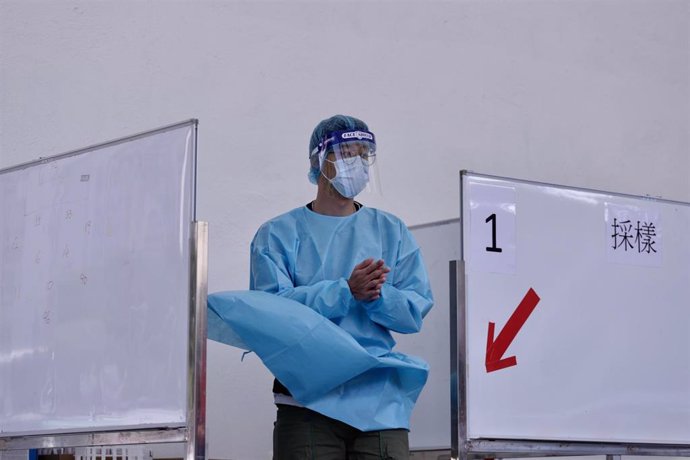 Un sanitario se echa gel desinfectante en las manos en Hong Kong.