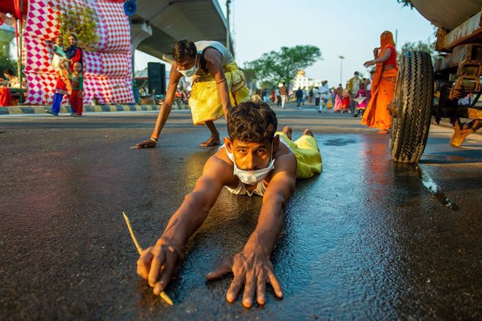 20 November 2020, India, Ghaziabad: A devotee lying on a road drags himself to the Hindon river as a ritual during the Chhath Puja celebration. Photo: Pradeep Gaur/SOPA Images via ZUMA Wire/dpa