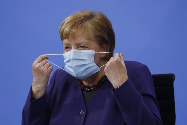 Angela Merjel se quita la mascarilla antes de una comparecencia en Berlín