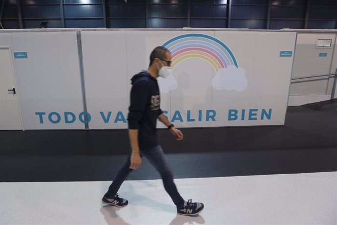 Un hombre pasa por un arcoiris con la frase 'Todo va a salir bien' en el hospital provisional H144 que se ha montado en el recinto ferial gijonés 'Luis Adaro', el día de su inauguración en Gijón, Asturias (España), a 11 de noviembre de 2020. 