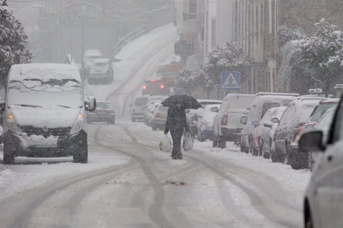 Un hombre camina en medio de una gran nevada en Becerrea, en Lugo, Galicia (España), a 4 de diciembre de 2020. Hoy se ha producido la primera gran nevada del otoño en la montaña lucense. La intensa nevada que está cayendo sobre el centro de la provincia