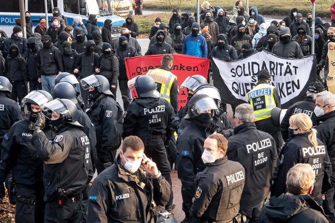 05 December 2020, Bremen: Policemen face counter-demonstrators while police forces attempt to enforce the ban on a protest against coronavirus restrictive measures as set forth by the German Federal Constitutional Court. Photo: Sina Schuldt/dpa