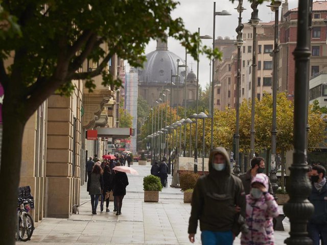 Transeúntes pasean por una calle de Pamplona protegidos con mascarilla