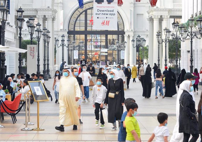 Personas con mascarilla en un centro comercial en Kuwait