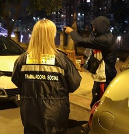 Una trabajadora social habla con una persona sin techo en Murcia