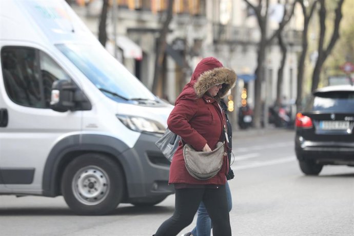 Transeúntes caminan abrigados por Madrid con la presencia de la borrasca 'Jorge' que desde el sábado se hace notar en la península dejando rachas muy fuertes de viento, lluvias y un frente frío, en Madrid (España), a 2 de marzo de 2020.