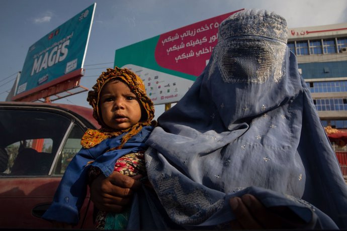 Mujer afgana con niño en Kabul