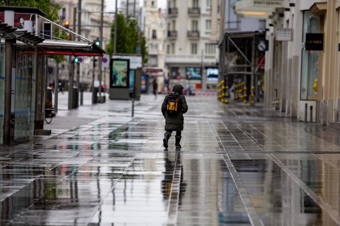 Una persona caminando por una calle de Madrid en un día de frío