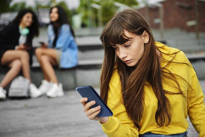 Una joven usa su teléfono móvil