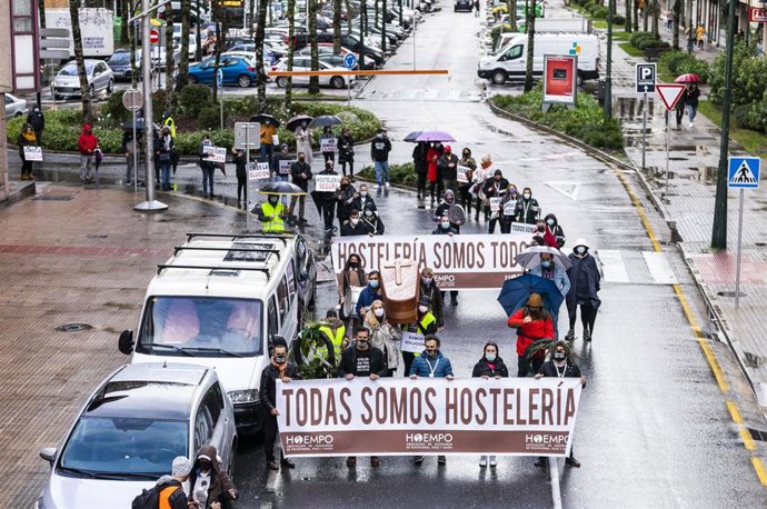 Dos niños se acercan a un grupo de hosteleros antes de que inicien una marcha en defensa del sector de la hostelería, en Pontevedra, Galicia (España), a 7 de diciembre de 2020. Al finalizar esta manifestación, en Campolongo, en Pontevedra, este grupo de