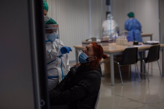 Una mujer recibe una prueba PCR en un dispositivo de cribados masivos en el barrio del Raval, en Barcelona