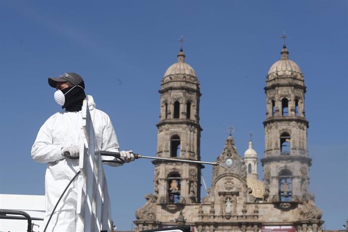Un trabajador sanitario desinfecta una zona cercana a la Basílica de nuestra señora de Zapopan, en México, en plena pandemia del coronavirus.