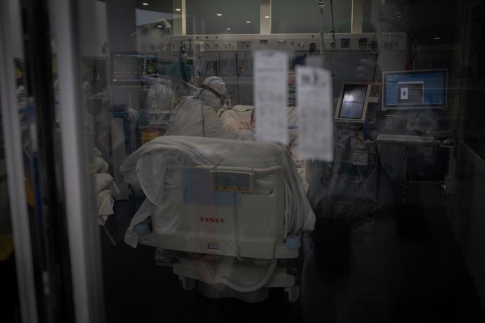 Trabajadores sanitarios protegidos atienden a un paciente en la Unidad de Cuidados Intensivos (Archivo)