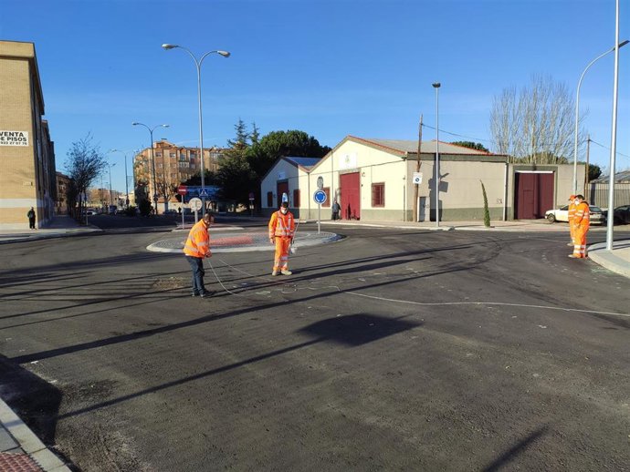 Operarios trabajan en la señalización horizontal de la nueva glorieta del barrio Puente Ladrillo.