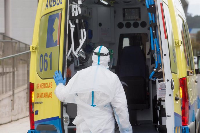Un trabajador sanitario totalmente protegido cierra la puerta de una ambulancia tras recoger a un anciano de la residencia de ancianos de San Cibrao donde se ha originado un brote de Covid-19, en San Cibrao, Lugo, Galicia, (España), a 9 de noviembre de 