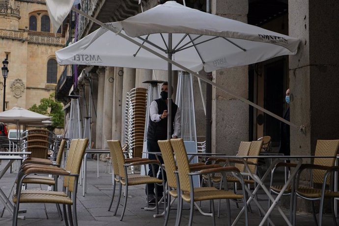 Un camarero colocando la terraza de su bar