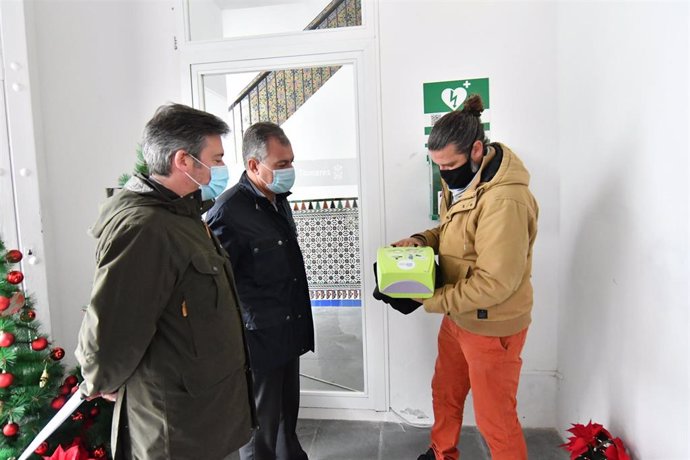 El alcalde de Tomares examina uno de los desfibriladores