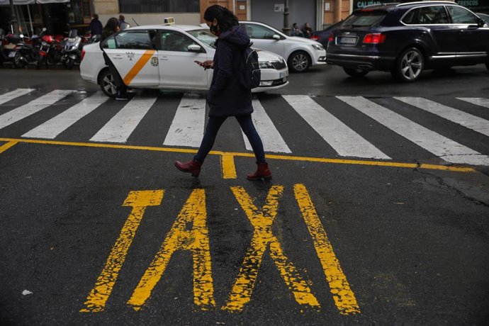 Un peatón cruza por una parada de taxis vacía