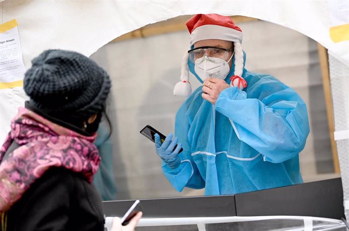 09 December 2020, Berlin: Amedical personnel wearing protective suit registers a woman for a smear, in the entrance area of the nightclub "KitKat-Club" which offers medically-supervised rapid antigen tests for a fee. 