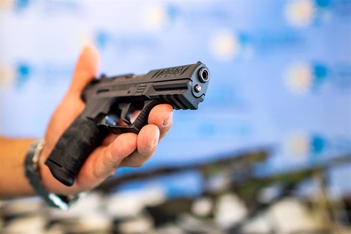 Un policía alemán sostiene una pistola durante un registro domiciliario enmarcado en una campaña contra el comercio ilegal de armas. 