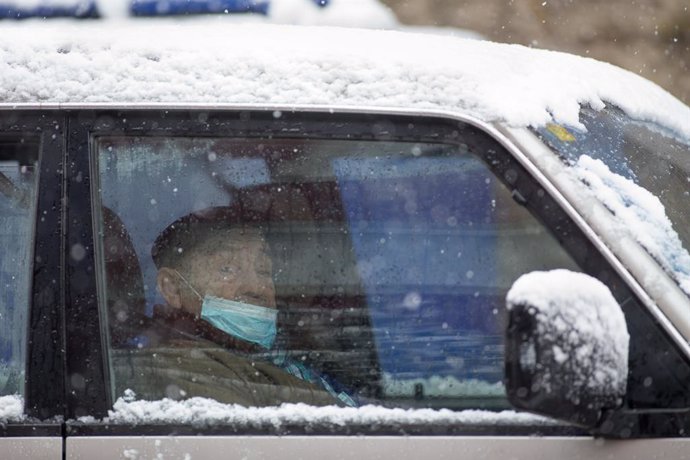 Un anciano con mascarilla permanece en su vehículo durante la nevada en Becerrea, en Lugo, Galicia (España), a 4 de diciembre de 2020.