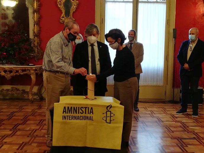 El coordinador de Amnistía Internacional Baleares, Miquel ngel Mayorga, el presidente del Parlament, Vicen Thomas, y la consellera de Asuntos Sociales, Fina Santiago, encienden una vela en el Parlament en el acto por el día deq los derechos humanos.