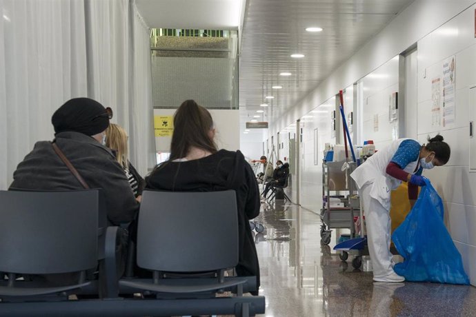 Varias pacientes esperan en una sala de espera mientras una mujer limpia en el CAP Masdevall el día en el que comienza la campaña de vacunación antigripal en la región, en Figueres, Girona (Catalunya), a 16 de octubre de 2020.La campaña coincide con la 