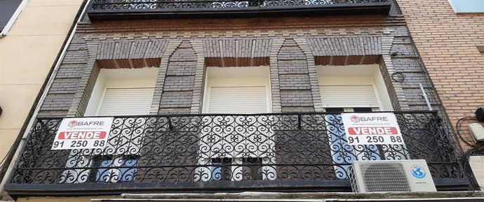 Cartel de 'se vende' en el balcón de un piso de un edificio de Madrid.