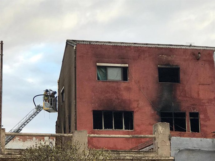 Feines d'extinció de l'incendi d'una nau a Badalona
