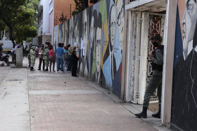 06 December 2020, Venezuela, Caracas: A soldier waits for the voters outside a polling station during the 2020 Venezuelan parliamentary election. Most opposition parties as well as interim president Guaido expect electoral fraud and have therefore calle