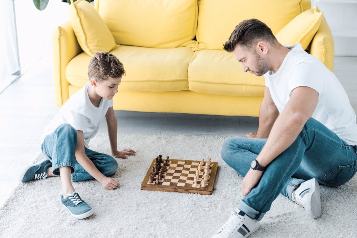 Chico inteligente aprende a jugar al ajedrez solo en su habitación en casa