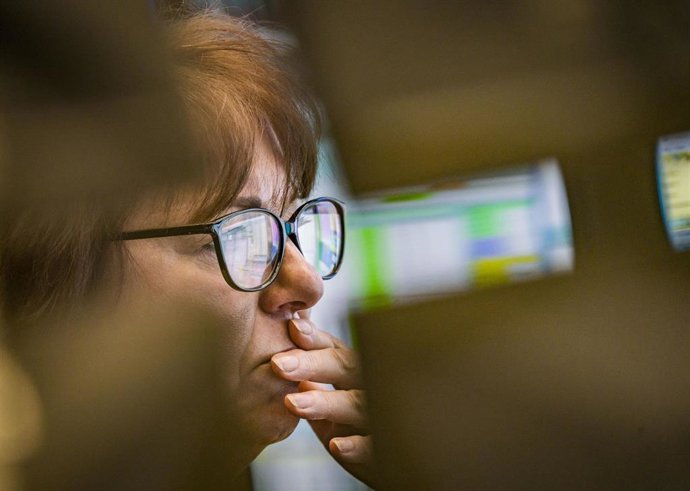26 February 2020, Hessen, Frankfurt_Main: A trader looks at the monitors at a trading room of the Frankfurt stock exchange. The Dax fell below 12,500 points in the morning to its lowest level since mid-October 2019, and more and more companies are putti