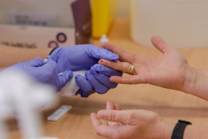 Personal sanitario de Cruz Roja saca sangre de un dedo a una persona para realizar el test rápido de detección de anticuerpos IgG e IgM en el Instituto de Formación Integral en Seguridad y Emergencias (IFISE), en Colmenar Viejo, Madrid (España), a 2 de 