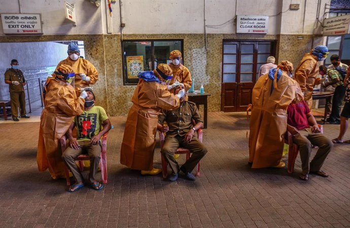 12 October 2020, Sri Lanka, Colombo: Sri Lankan health officials take swabs from people for coronavirus (COVID-19) tests at Fort railway station. Photo: Pradeep Dambarage/ZUMA Wire/dpa