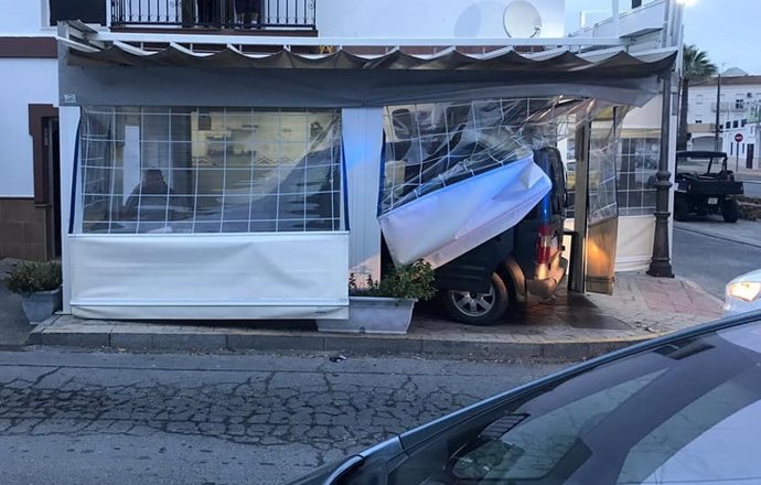 Imagen del coche accidentado dentro de la terraza del bar de Lepe (Huelva).