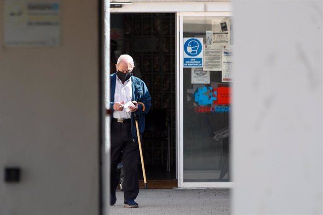 Un anciano sale por la puerta del Centro de Salud Valleaguado, Coslada.