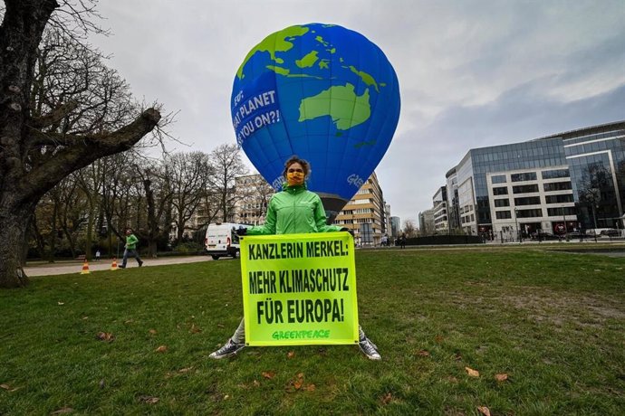 Activistas de Greenpeace despliegan en Bruselas (Bélgica) un globo aerostático para denunciar la falta de ambición climática de los Veintiesiete a los que reclaman una reducción de CO2 más elevada para 2030.