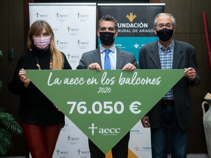El presidente de Fundación Caja Rural de Aragón, Luis Ignacio Lucas, entrega una gran pañoleta solidaria con la cifra total recaudada por varias iniciativas desarrolladas en las provincias de Huesca y Zaragoza desde agosto en favor de la AECC.