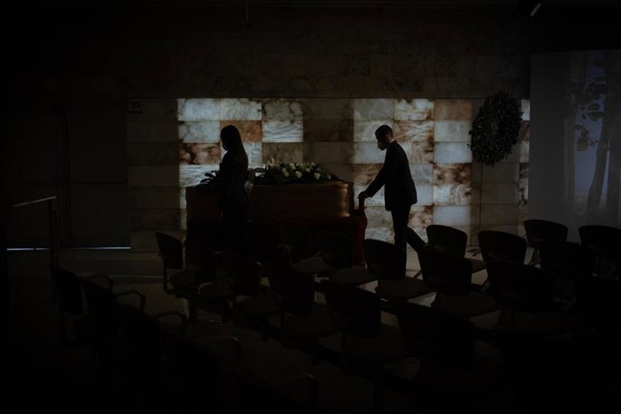 Féretro junto a una pantalla gigante instalada en la sala de ceremonias de Les Corts durante un funeral, en Barcelona