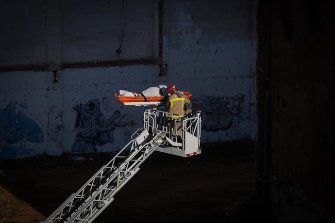 Bomberos retiran el cadáver de una de las personas fallecidas en el incendio de ayer en la nave okupada del barrio de Gorg, en Badalona, Barcelona, Catalunya (España), a 10 de diciembre de 2020. Un incendio la pasada noche en una nave okupada y abandona
