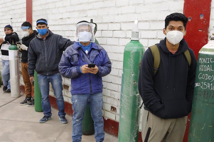 Un grupo de personas hace cola para poder recargar sus bombonas de oxígeno.