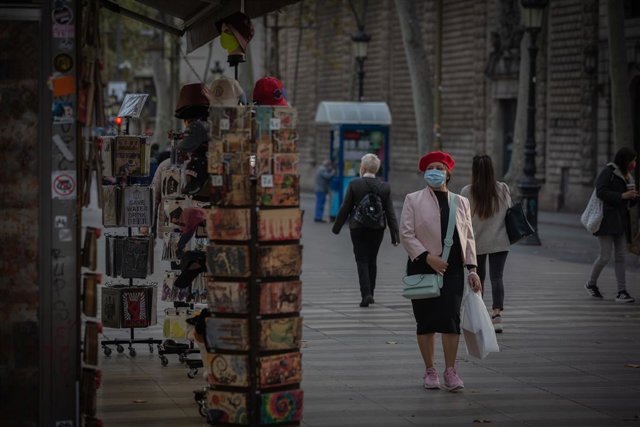 Una dona a una botiga d'articles turístics a Barcelona, Catalunya (Espanya)