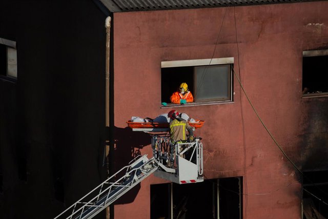 Els Bombers retiren el cos d'una de les víctimes en l'incendi de la nau de Badalona, Barcelona, Catalunya (Espanya), 10 de desembre del 2020. 
