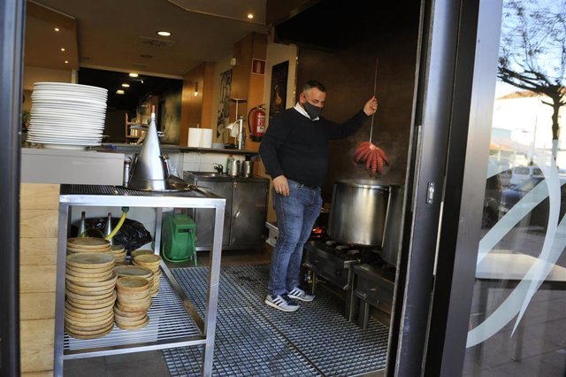 Un camarero dentro de su establecimiento abierto en O Carballiño.