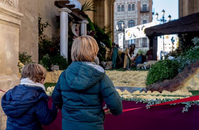 Dos niños contemplan el Belén puesto en el Ayuntamiento de Sevilla.