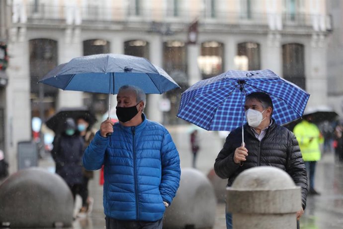 Dos personas pasean protegidas con paraguas por el centro de la capital, en Madrid, (España), a 27 de noviembre de 2020. El año hidrológico, que comenzó el 1 de octubre, acumula hasta el 24 de noviembre un 16 por ciento menos lluvias de lo normal, según