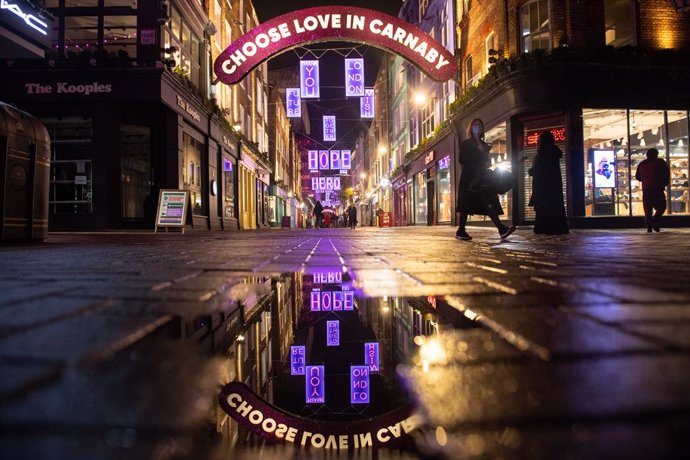 18 November 2020, England, London: People wander through Carnaby Street which is decorated with the Christmas lights as it appears almost empty due to the continuity of the four-week national lockdown to curb the spread of coronavirus. Photo: Dominic Li