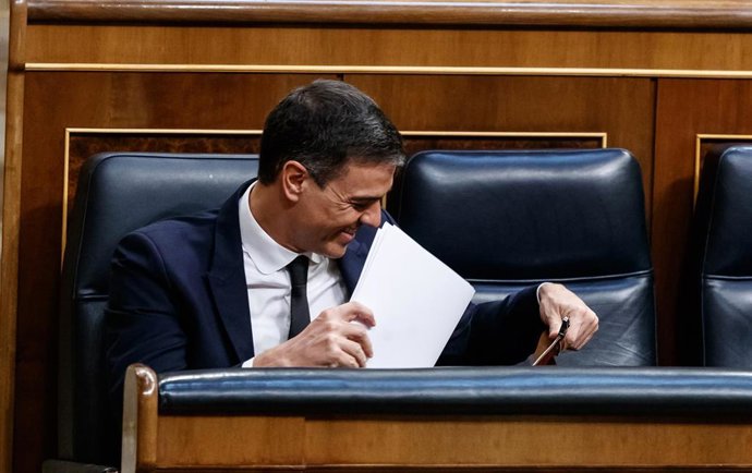 El presidente del Gobierno, Pedro Sánchez, sonríe desde su escaño del Congreso.
