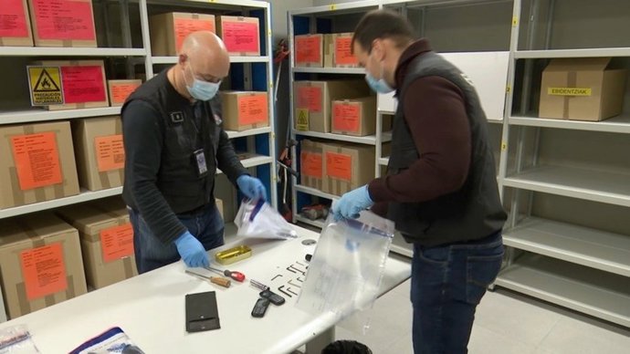 Agentes de la Ertzaintza clasifican el material incautado a las tres detenidas.